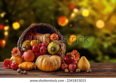 Thanksgiving day still life, background with empty copy space. Pumpkin harvest in wicker basket. Squash, vegetable autumn fruit, apples, and nuts on a wooden table. Halloween decoration fall design. Royalty-Free Stock Photo #2341815015
