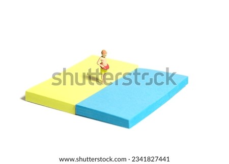 Creative miniature people toy figure photography. Sticky notes installation. Young boy, kids, with rubber ring tube standing at beach shore. Isolated on white background. Image photo