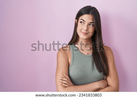 Hispanic woman standing over pink background smiling looking to the side and staring away thinking.  Royalty-Free Stock Photo #2341833803