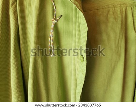 A close-up of the elements of a green shirt showing intricate patterns and textures, showing the vibrant hues of nature in a fashion masterpiece.