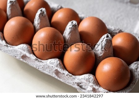 A few brown eggs among the cells of a large cardboard bag, a chicken egg as a valuable nutritious product, a tray for carrying and storing fragile eggs. A full package of eggs, an important food item