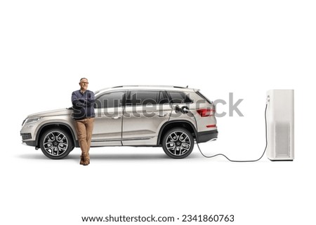 Mature man with a SUV plugged into an electric vehicle charging station isolated on white background
