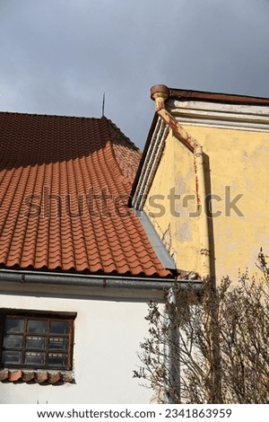 a round downspout is attached to the corner of the building
