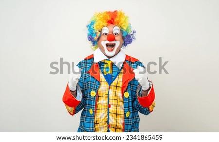 Mr Clown. Portrait of Funny shocked face comedian Clown man in colorful costume wearing wig standing posing smiling to camera. Happy expression amazed bozo in various pose on isolated background.