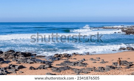 Surfers grouped surfing rocky beach coves small ocean blue waves a scenic outdoors lifestyle.