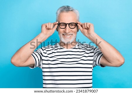 Photo portrait of funny old male touch specs try on check eyesight wear trendy striped garment isolated on blue color background Royalty-Free Stock Photo #2341879007