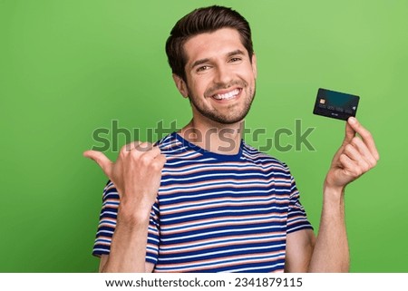 Photo of young guy advertiser new modern wireless plastic card point finger empty space new purchase isolated on green color background