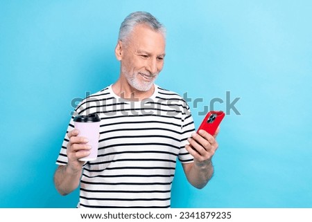 Photo of smiling cheerful pensioner wear trendy clothes drink coffee use phone iphone read news post isolated on blue color background