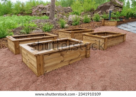 Empty wooden planter boxes ready to be used. With a planter box, you can easily produce vegetables for your own needs. Royalty-Free Stock Photo #2341910109
