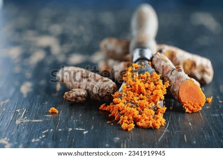 Freshly ground turmeric root containing curcumin, an anti-inflammatory and antioxidant substance. Selective focus with blurred background and foreground.