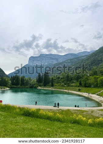 Alpine lake with mountains in the background. Some fishermen along the coast. Picture taken in the French alps.