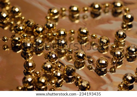 The golden necklace is on brown background.