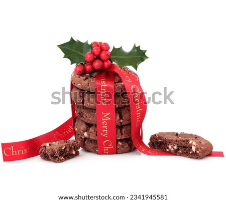 Chocolate chip cookie biscuits with merry christmas red ribbon and half eaten biscuit over white background.