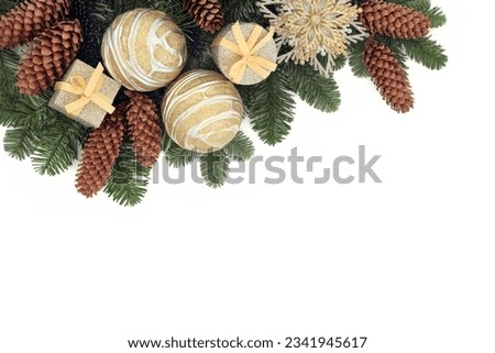 Christmas background border with gold bauble decorations, pine cones and winter spruce fir over white with copy space.