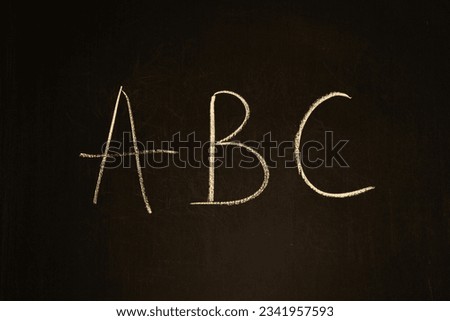 Chalk drawing on a blackboard. Letters ABC on wooden board. School chalkboard. Alphabet concept. Handwritten text. Preschool education. Knowledge concept. Language symbols with copy space. 