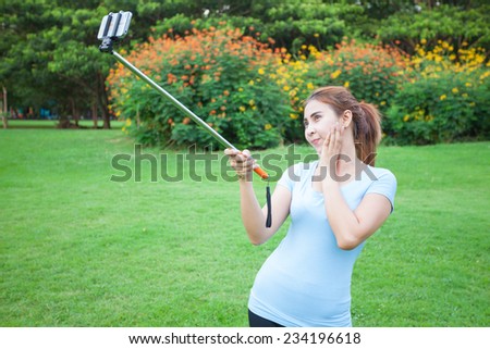 Pretty young female tourist takes travel selfie at the park