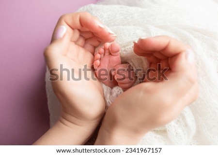 baby feet in the hands of the mother. parents ' wedding rings on the toes of a newborn Royalty-Free Stock Photo #2341967157