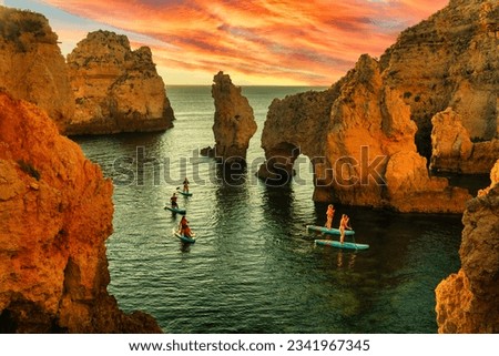 Stand up paddle boarders SUP on the water of the sea. Sunrise at sea. Active rest on the sea. Coastal dream, Algarve Portugal (Ponta da Piedade) Royalty-Free Stock Photo #2341967345