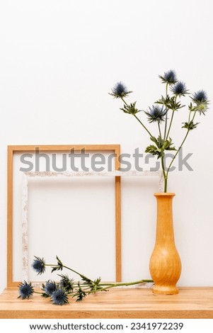 Modern wooden furniture with empty Wall and decorative wooden frames and flowers in a wooden vase