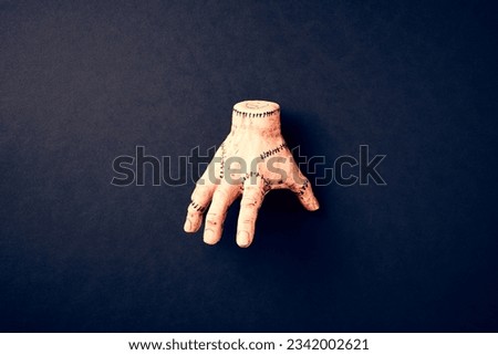Severed hand Thing from Addams Family on dark background. Halloween holiday decoration. Royalty-Free Stock Photo #2342002621