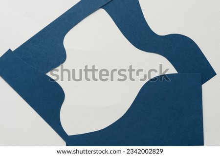 cut blue paper shape with wavy or curvy edges arranged as a frame or box Royalty-Free Stock Photo #2342002829