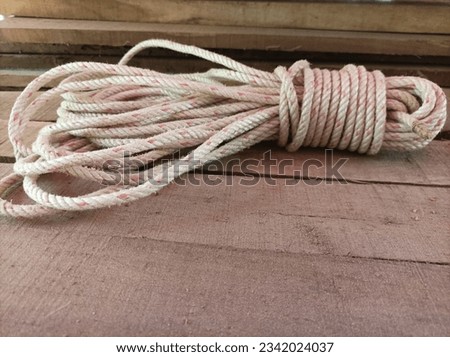 rolled up plastic rope on a wooden background. Royalty-Free Stock Photo #2342024037