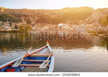tip of wooden boat with the flag of bolivia on a lake at sunset in hispanic america