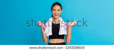 Asian beautiful happy woman exercise with dumbbell isolated on blue color background.Concept of healthy girl workout. Royalty-Free Stock Photo #2342038655