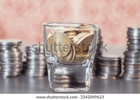 A stack of coins sits in a wine glass