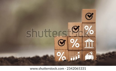 Wooden block with percentage symbols and check list for rising is mortgage interest rate placed on soil with natural background. Royalty-Free Stock Photo #2342065331