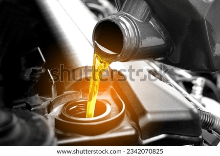 Refueling and pouring oil quality into the engine motor car Transmission and Maintenance Gear .Energy fuel concept. Royalty-Free Stock Photo #2342070825