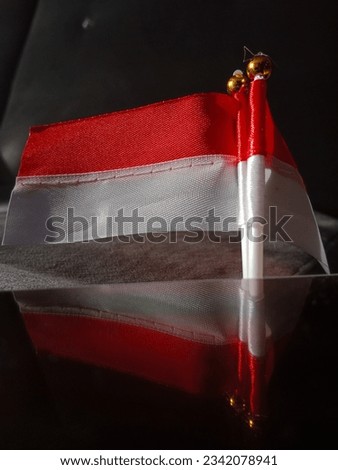 Close up of double miniature Indonesian Red and White Flags with reflections, dark bokeh background. to celebrate the 17th August independence day