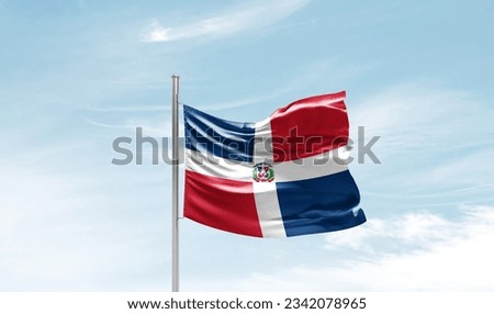 Dominican Republic national flag waving in beautiful sky. Royalty-Free Stock Photo #2342078965