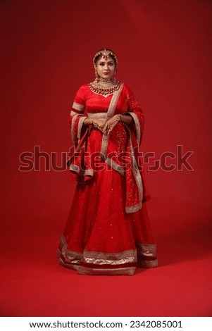 indian bride on red lehenga with red colour backgraund. this photo is raw without edited.
