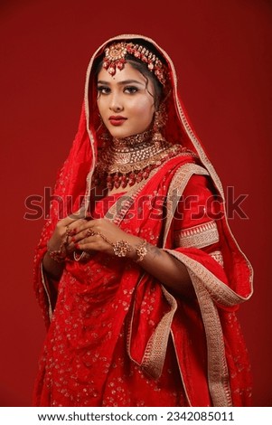 indian bride on red lehenga with red colour backgraund. this photo is raw without edited.

