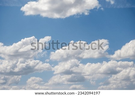 White powerful cumulus clouds against the blue sky.