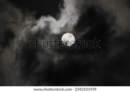 full moon covered by clouds   