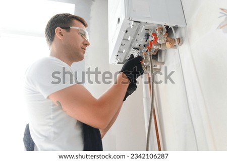 Professional plumber checking a boiler and pipes, boiler service concept. Royalty-Free Stock Photo #2342106287