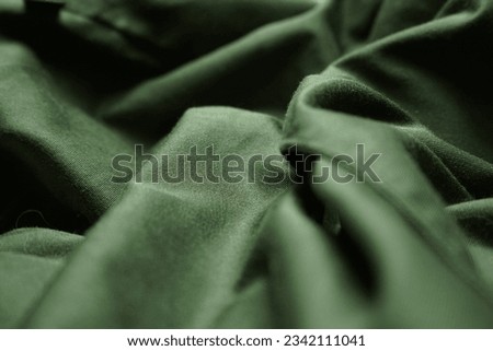 green or dark green fabric that is wavy and crumpled, can be used as an abstract background