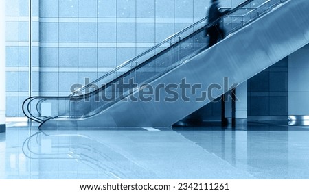 Single business people on escalator, blurred motion Royalty-Free Stock Photo #2342111261