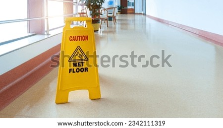 Freshly mopped hallway with a caution sign in English