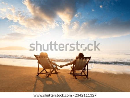 Young couple sunbathing on beach chair Royalty-Free Stock Photo #2342111327