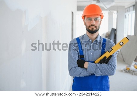 Construction Worker in blue uniform with spirit level.