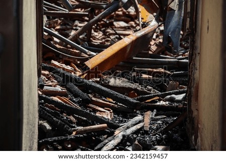 Burning wood and metal collapsing from a building fire is photographed from the doorway