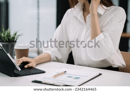 Business women talk mobile phones and working on laptop computers, online business.