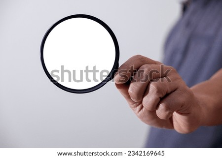 man holding a magnifying glass The concept of technology file search engine, forensic data, computer crime and device investigation, abstract close-up view,