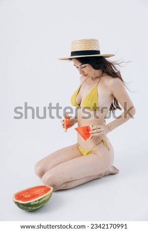 Slender athletic girl in summer swimsuit holds watermelon. Rest, vacation by sea