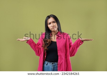 Expression confused asian young woman have no idea, maybe,shrugging shoulders in bewilderment, doubting and feeling uncertain, don't know answer. Isolated on green pastel background Royalty-Free Stock Photo #2342184261