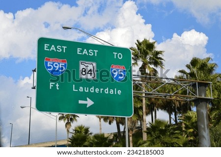 Fort Lauderdale Highway sign with directional arrow directing traffic east to interstate 595, interstate 95 and state road 85.  Royalty-Free Stock Photo #2342185003