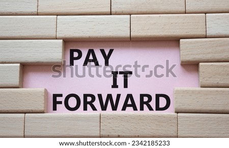 Pay it forward symbol. Concept words Pay it forward on wooden blocks. Beautiful pink background. Business and Pay it forward concept. Copy space.
